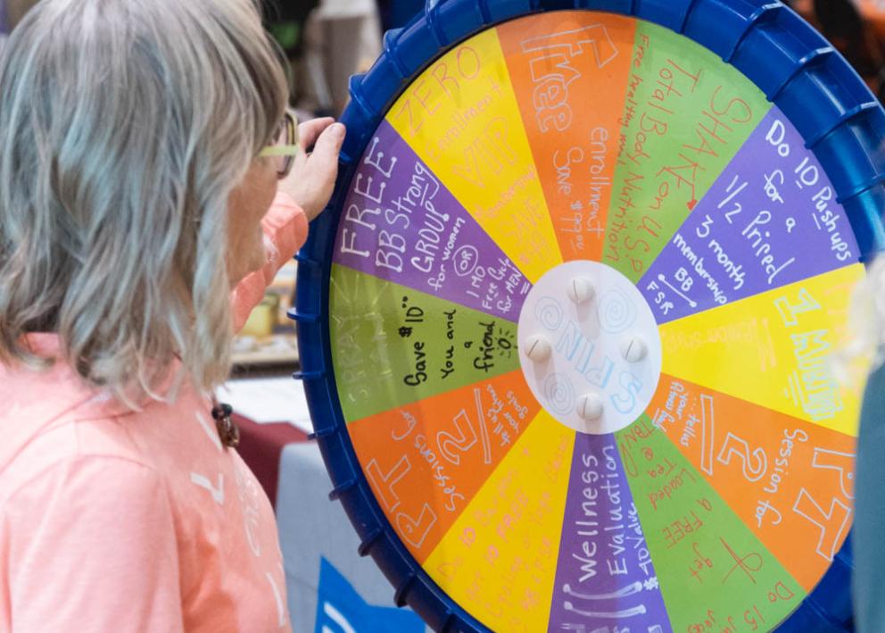 A fair attendee spins a wheel to win a prize