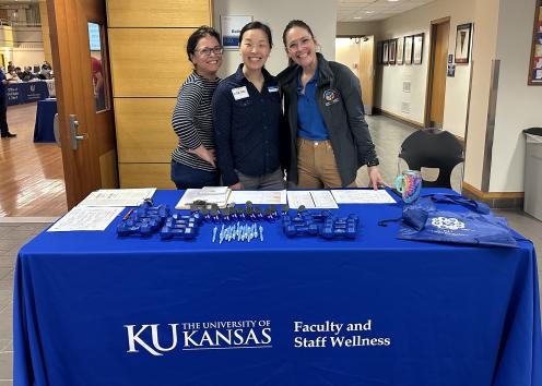 Three staff members at fair check-in table