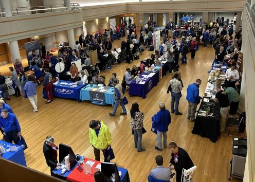 Wide view of entire fair floor showing vendors and attendees